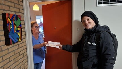 Wijkbeheerder Daan van De Sleutels bedankt huurder voor het meedoen aan het reputatie-onderzoek. De huurder ontvangt haar cadeaubon.